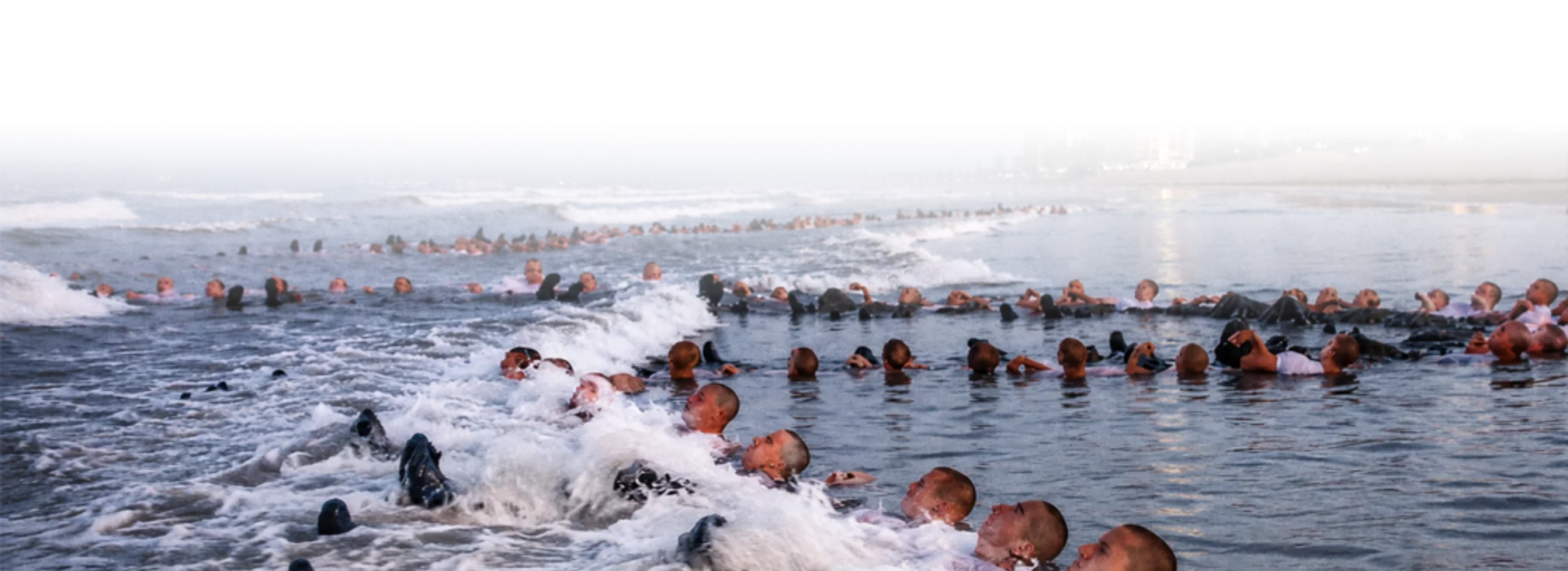Aspirantes a Navy SEAL formados en la rompiente durante la inmersión de la Semana del Infierno