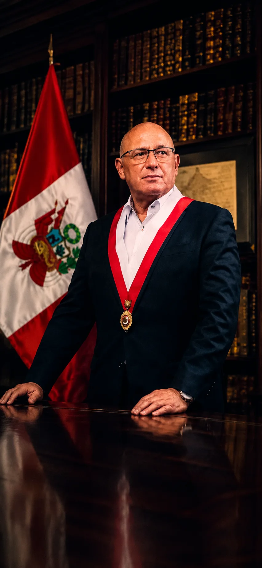 El Vicealmirante Calisto Giampietri con la banda presidencial junto a la bandera del Perú